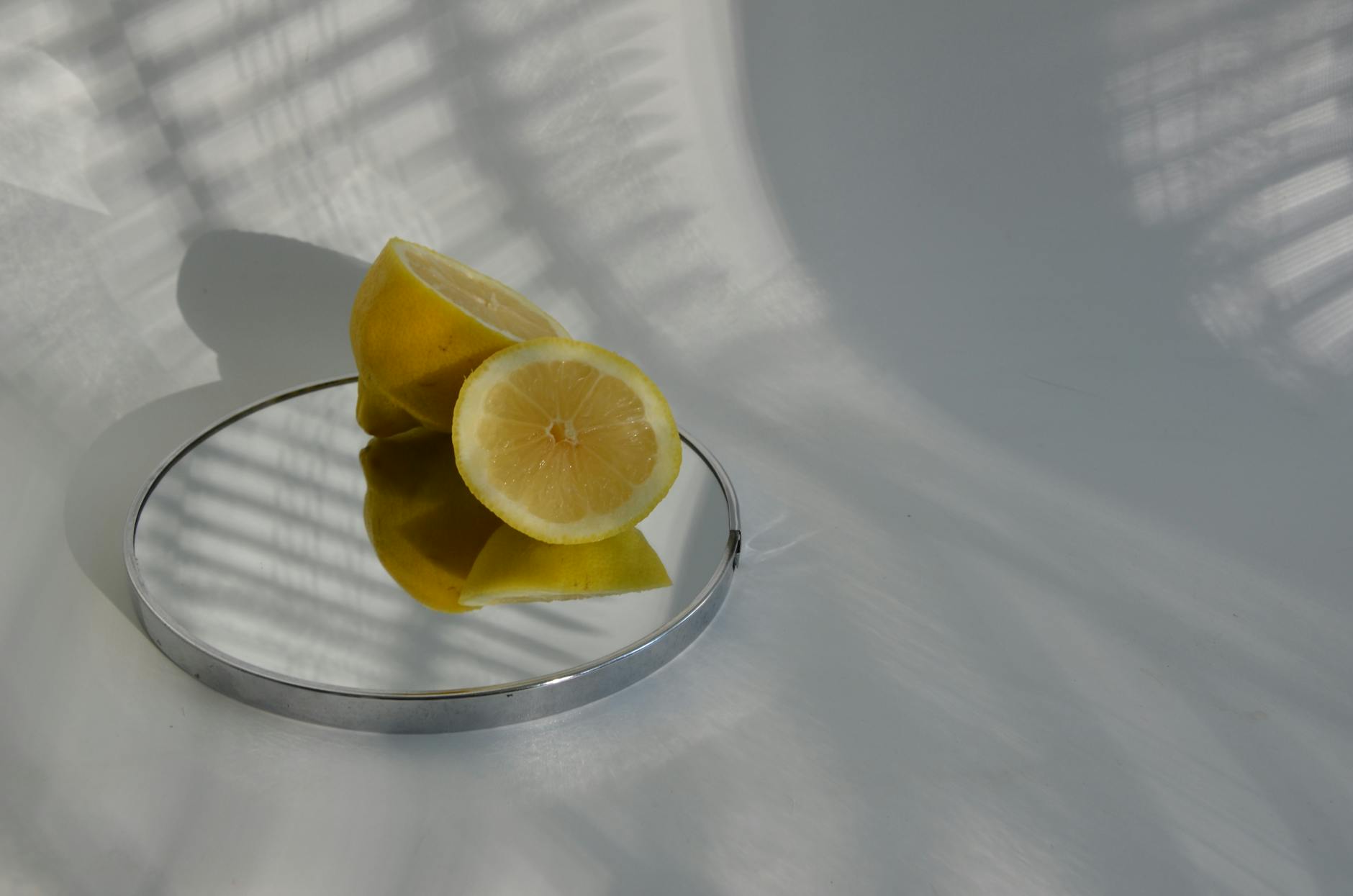 Two smiling women with lemon slices and tropical plants, expressing joy and fun indoors