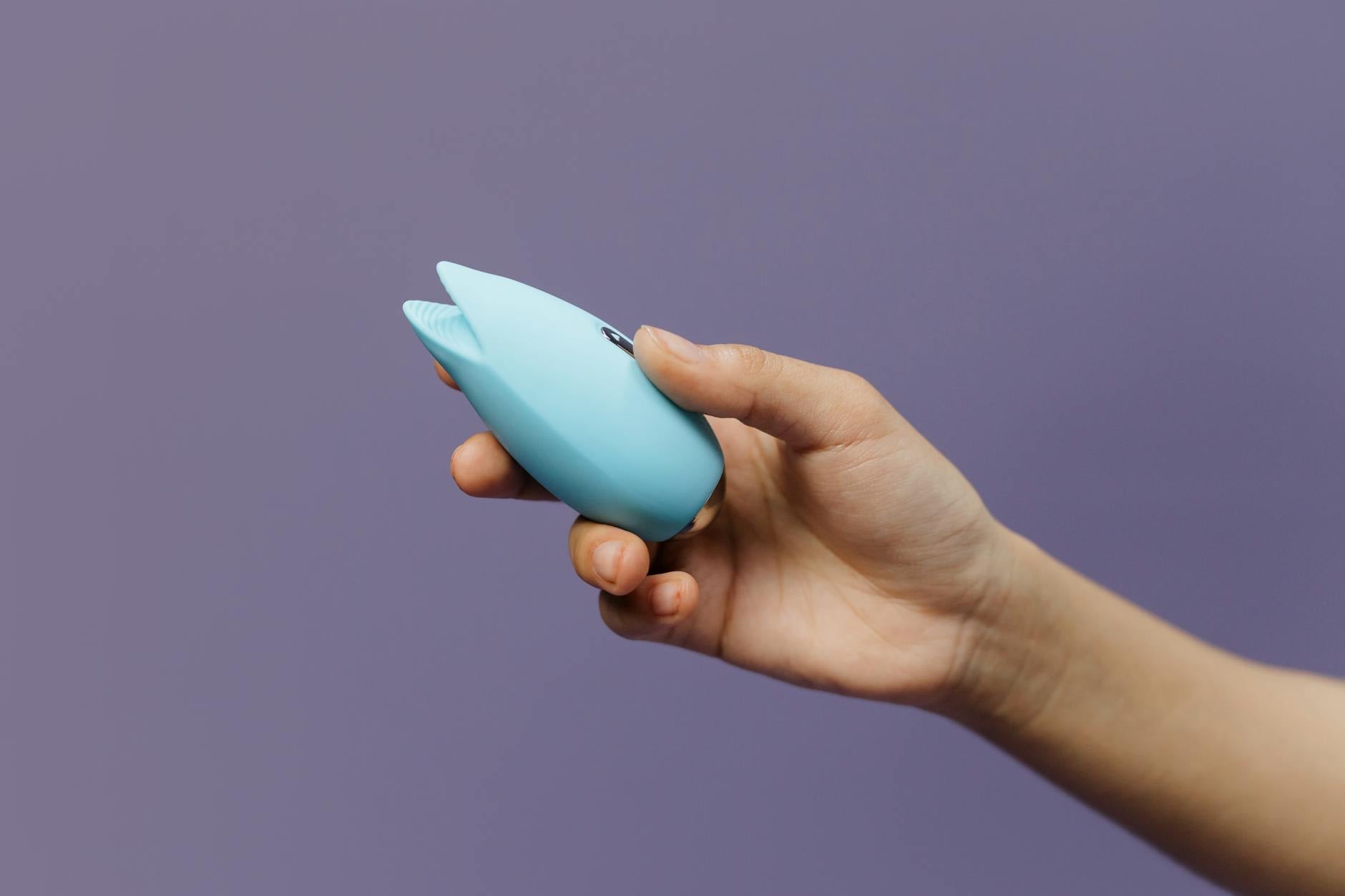 Woman holding lemon clitoral vibrators in a contemplative, gentle moment of self-care